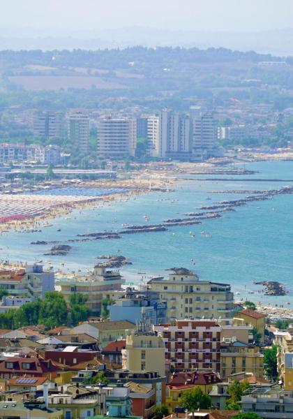 Vue panoramique d'une ville côtière avec une plage bondée.